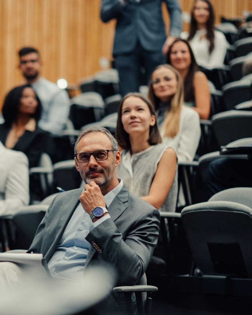 Thoughtful man seated in lecture hall audience