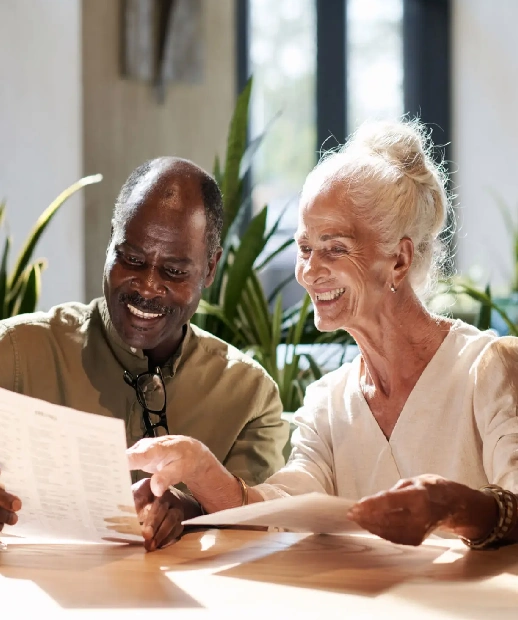 Older adults smiling while reviewing documents